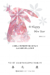花を背景にしたピンクのうさぎのイラストの年賀状